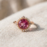 Duchess Pink Topaz Ring in rose gold photographed in warm sunlight on textured ivory fabric