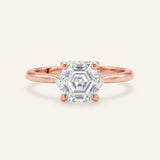 Hexagon step-cut moissanite ring in rose gold on an ivory background