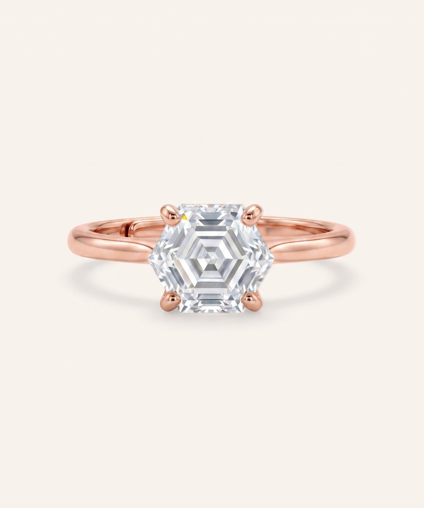 Hexagon step-cut moissanite ring in rose gold on an ivory background