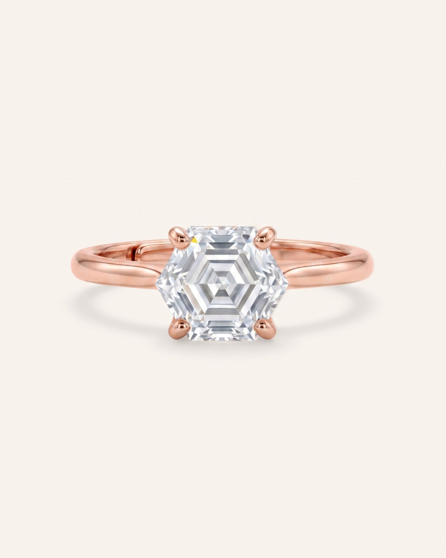 Hexagon step-cut moissanite ring in rose gold on an ivory background