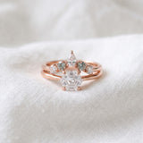 Hexagon step-cut moissanite ring in rose gold styled on ivory linen with stacking rings
