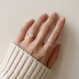 Hexagon step-cut moissanite ring in rose gold worn on a hand