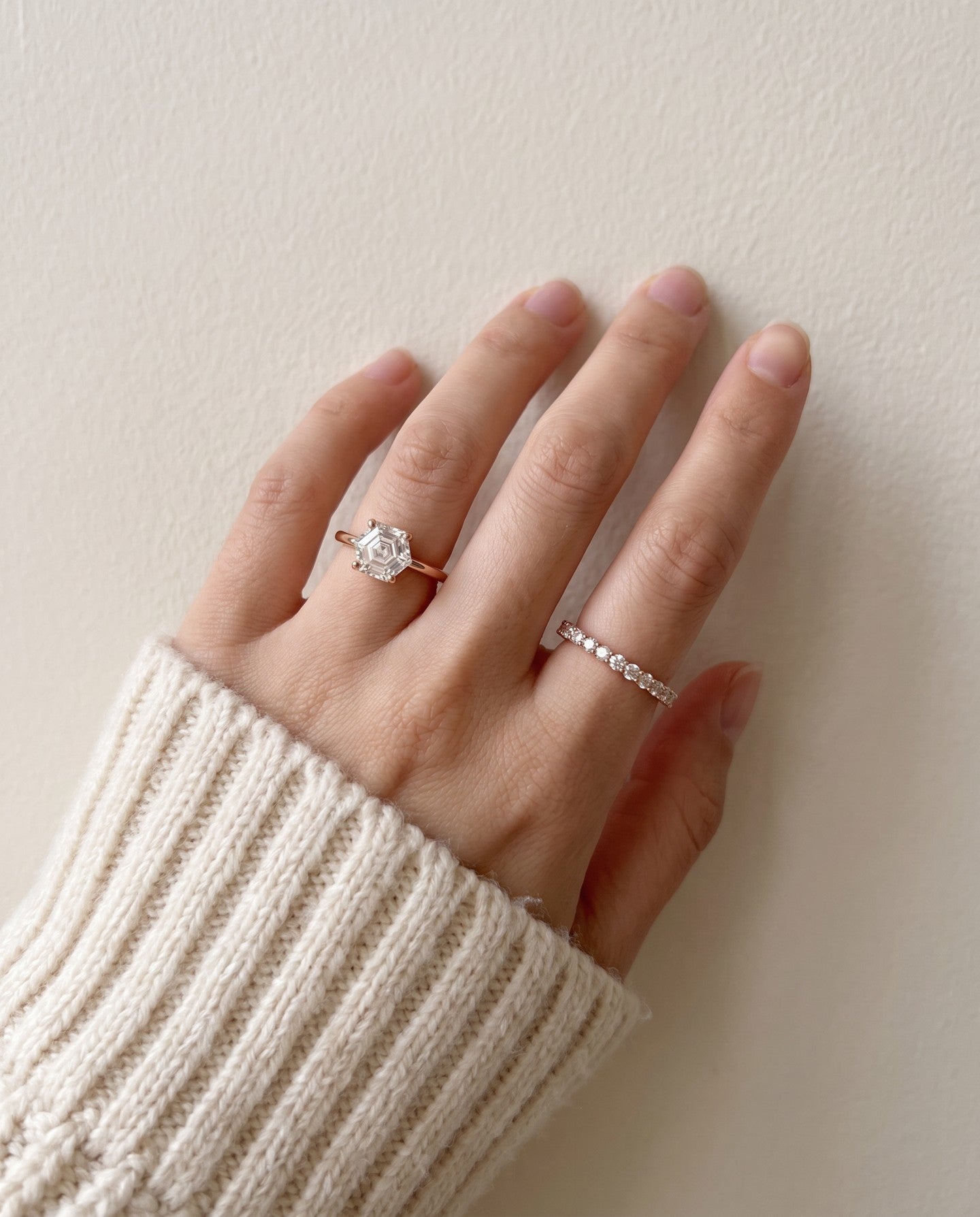 Hexagon step-cut moissanite ring in rose gold worn on a hand