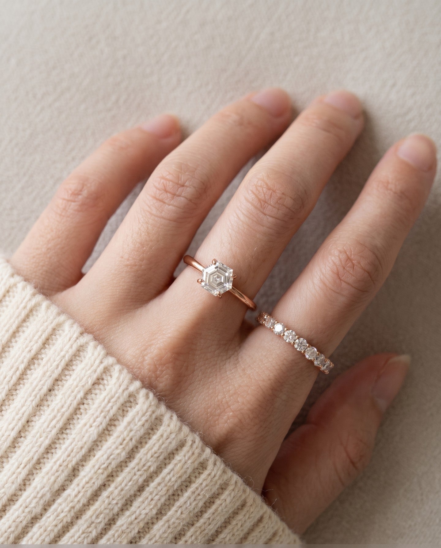 Hexagon step-cut moissanite ring in rose gold worn on a hand