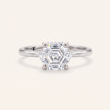 Hexagon step-cut moissanite ring in silver on an ivory background