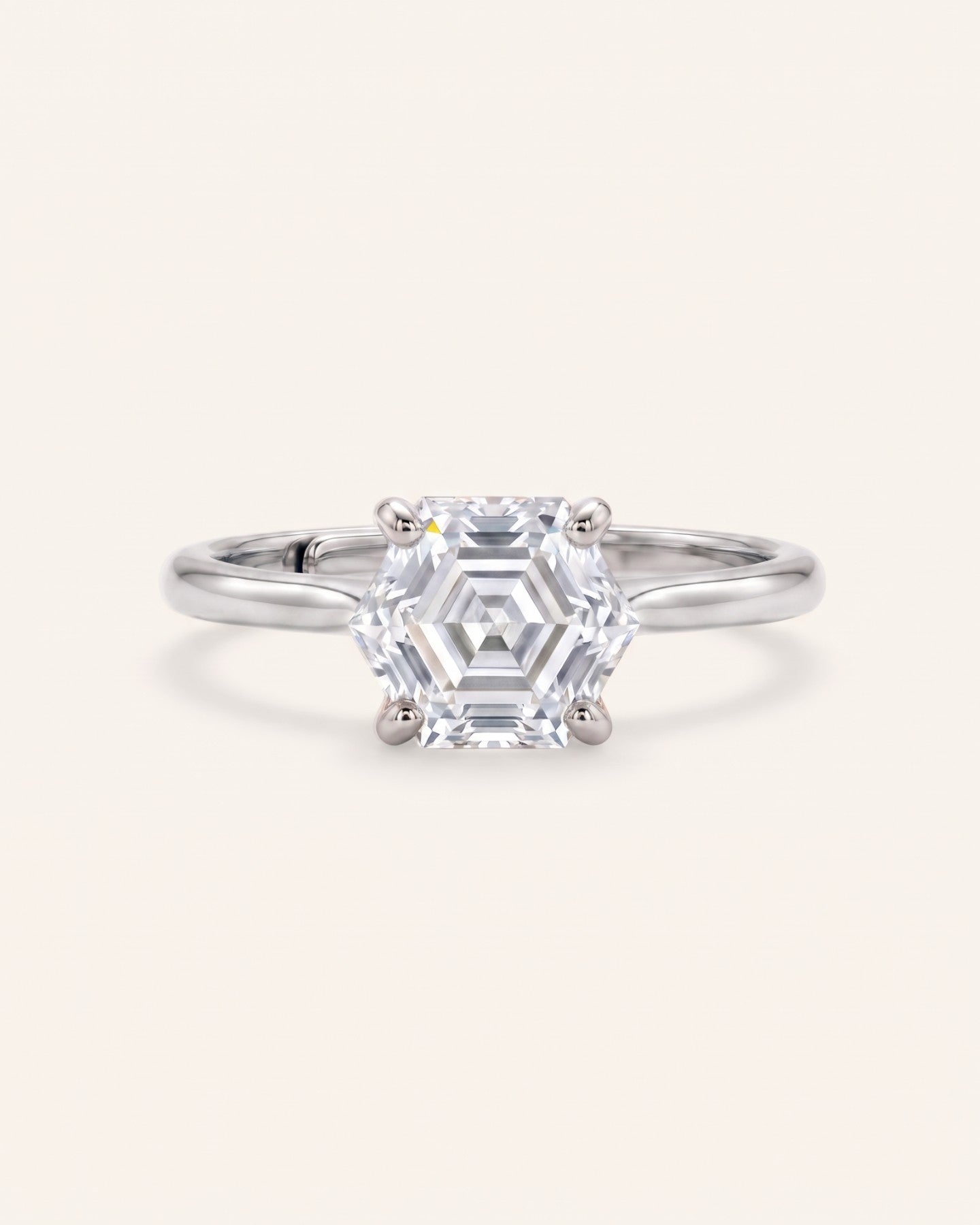Hexagon step-cut moissanite ring in silver on an ivory background