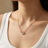 Rose gold interlocking rings moissanite necklace worn with a white neckline