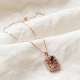 Jewel Box Multi-Gemstone Necklace in rose gold, arranged on ivory linen with its box chain