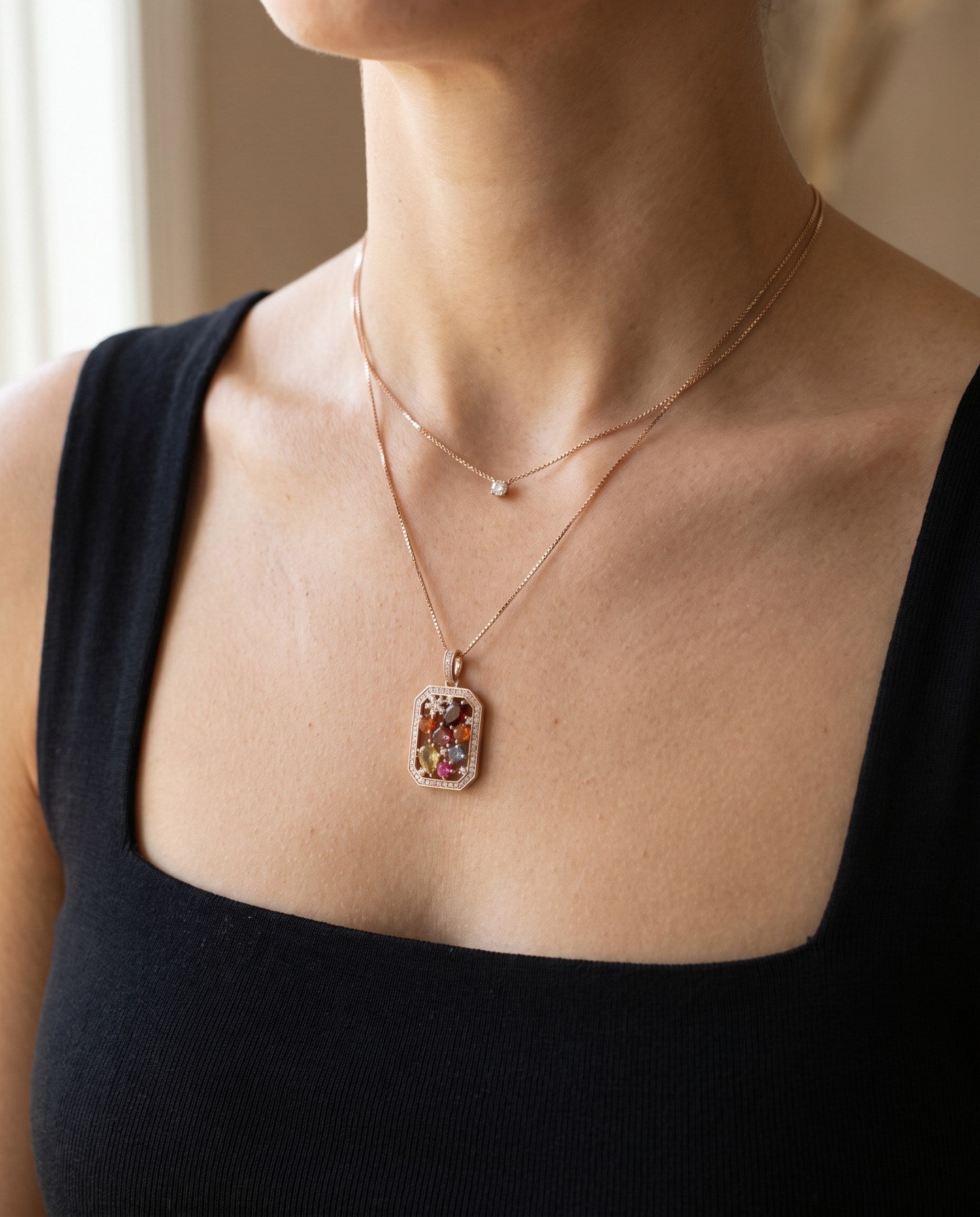 Jewel Box Multi-Gemstone Necklace in rose gold, worn with a black neckline in window light