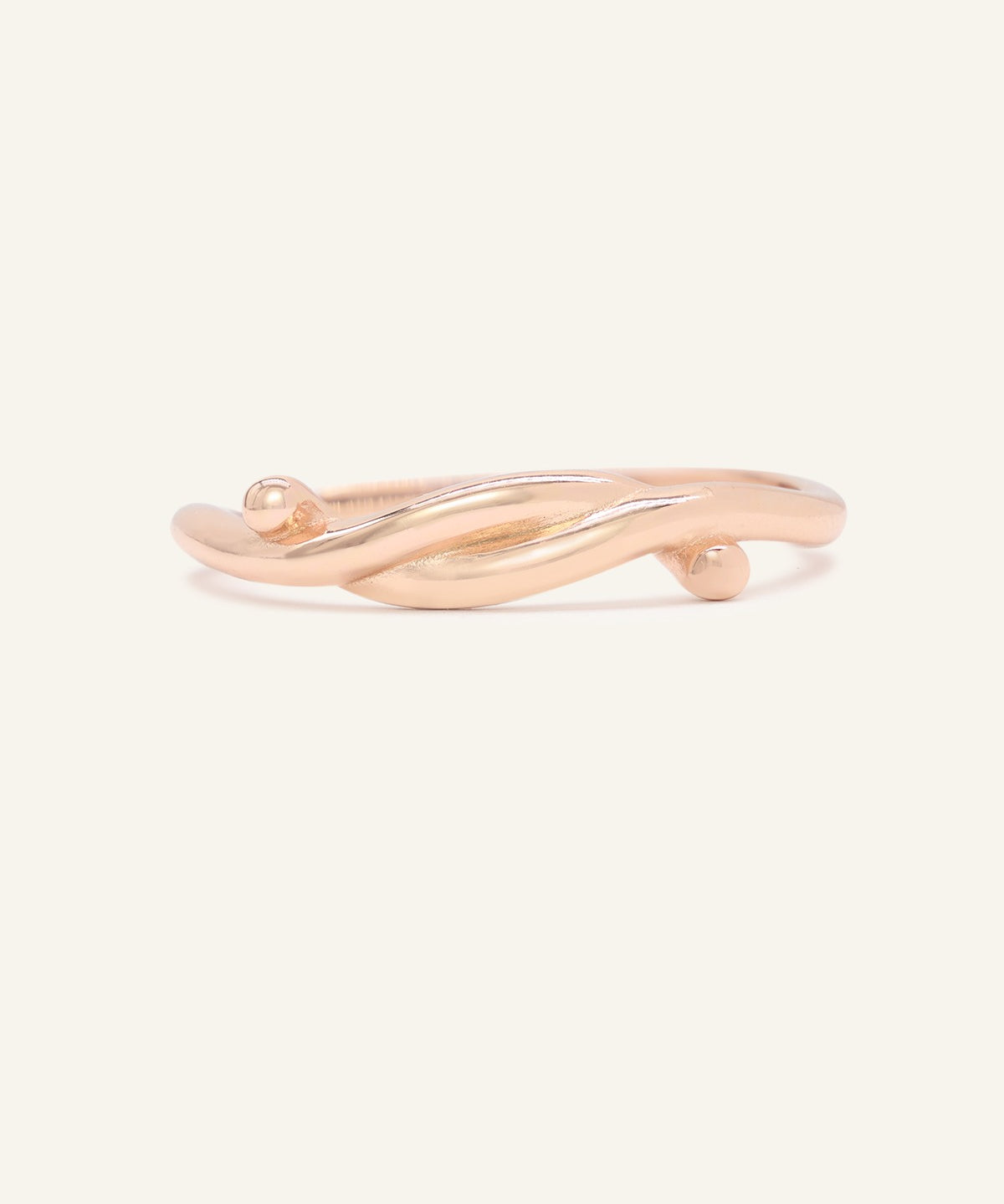 Knots End Ring in rose gold, front view of the intertwined knot band on warm ivory