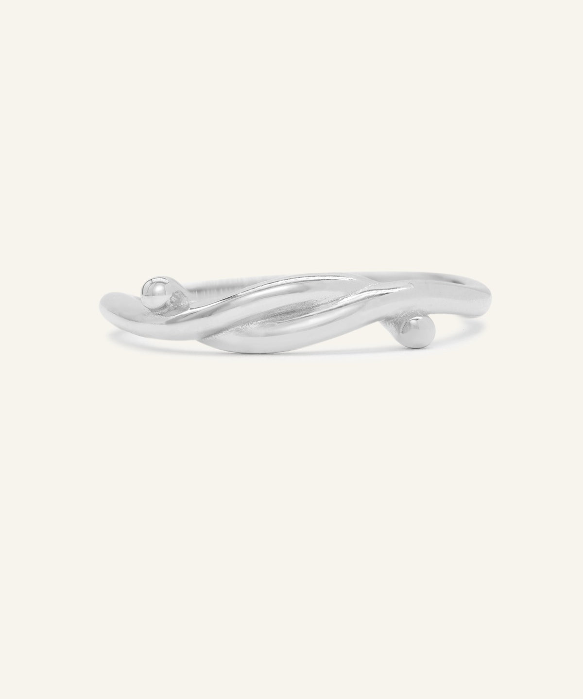 Knots End Ring in silver, front view of the intertwined knot band on warm ivory