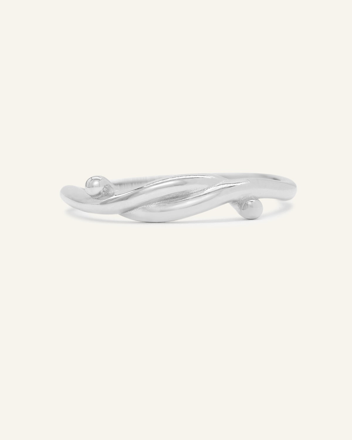 Knots End Ring in silver, front view of the intertwined knot band on warm ivory