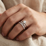 Knots End Ring in silver, worn as part of a silver ring stack