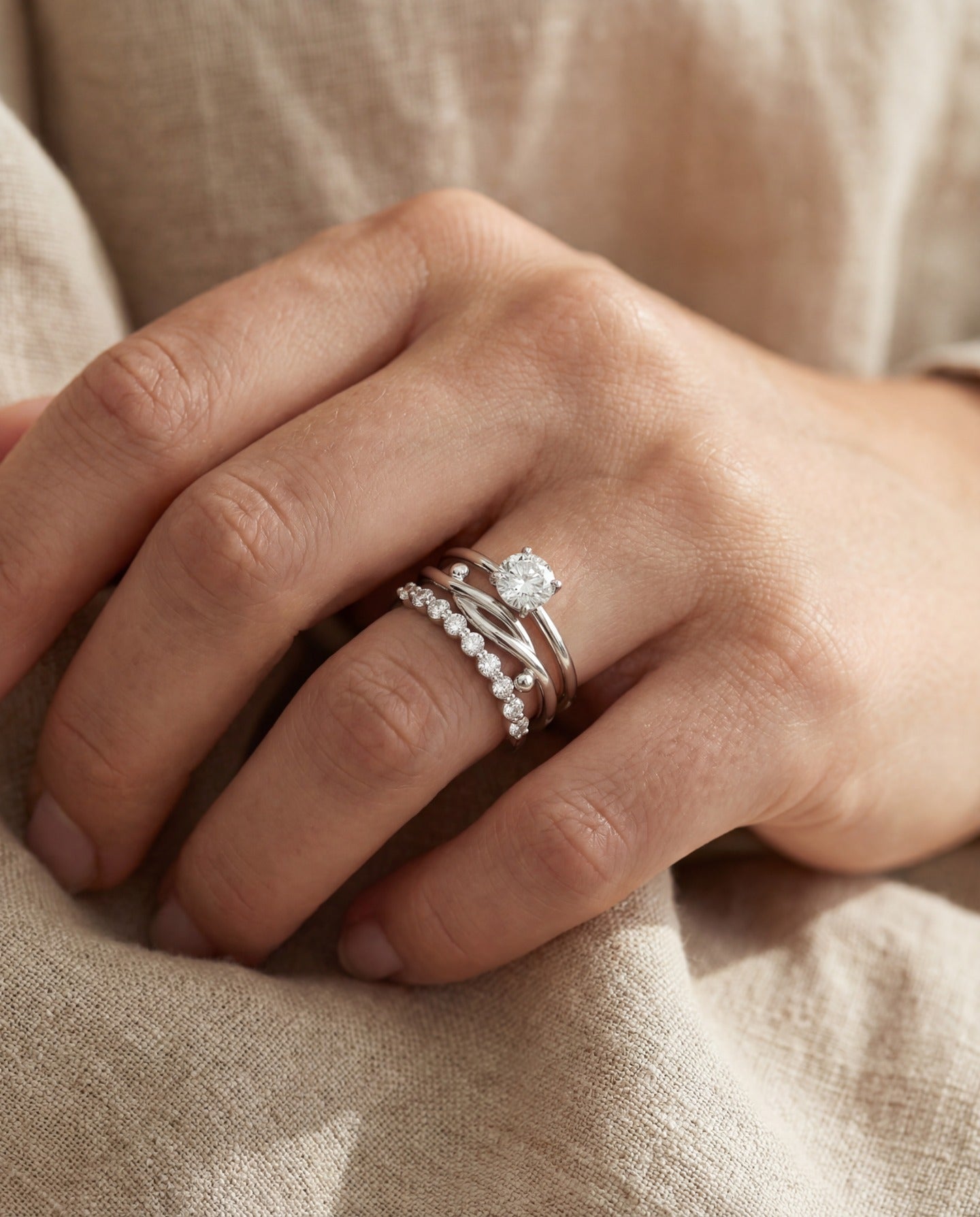 Knots End Ring in silver, worn as part of a silver ring stack