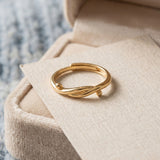 Knots End Ring in yellow gold, angled view on a cream jewellery cushion