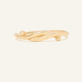 Knots End Ring in yellow gold, front view of the intertwined knot band on warm ivory