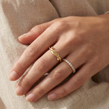 Knots End Ring in yellow gold, worn on a hand with a delicate stacking ring