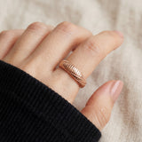 Linear Stripes Band in rose gold, close-up worn on a hand with a black knit sleeve