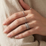 Linear Stripes Band in silver, worn in a silver ring stack with an ivory knit sleeve