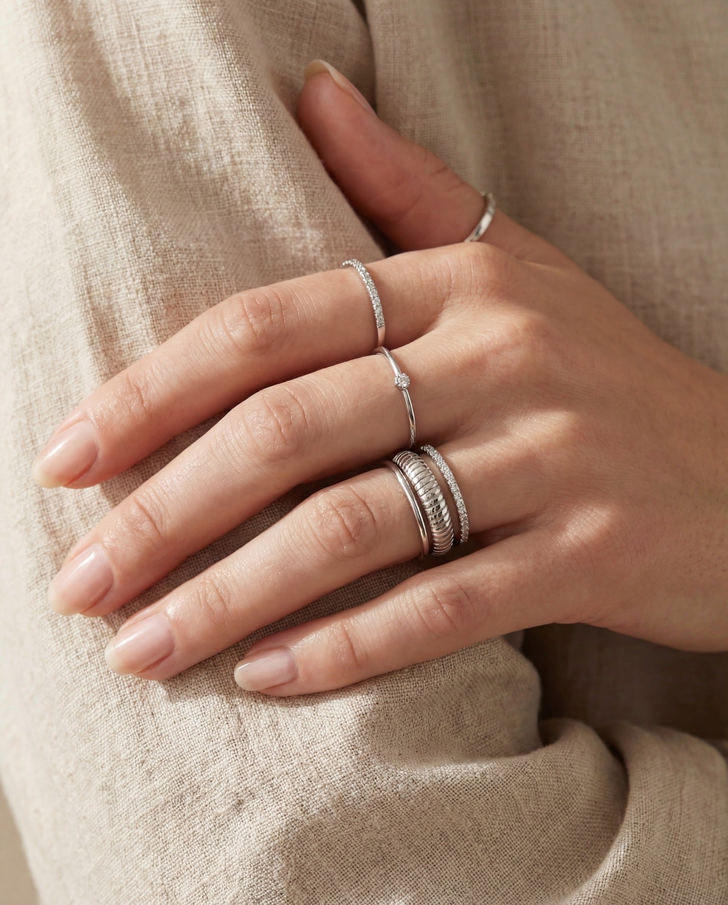 Linear Stripes Band in silver, worn in a silver ring stack with an ivory knit sleeve