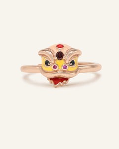Close-up of the Lion Dance Garnet Ring in rose gold, resting on a warm linen background