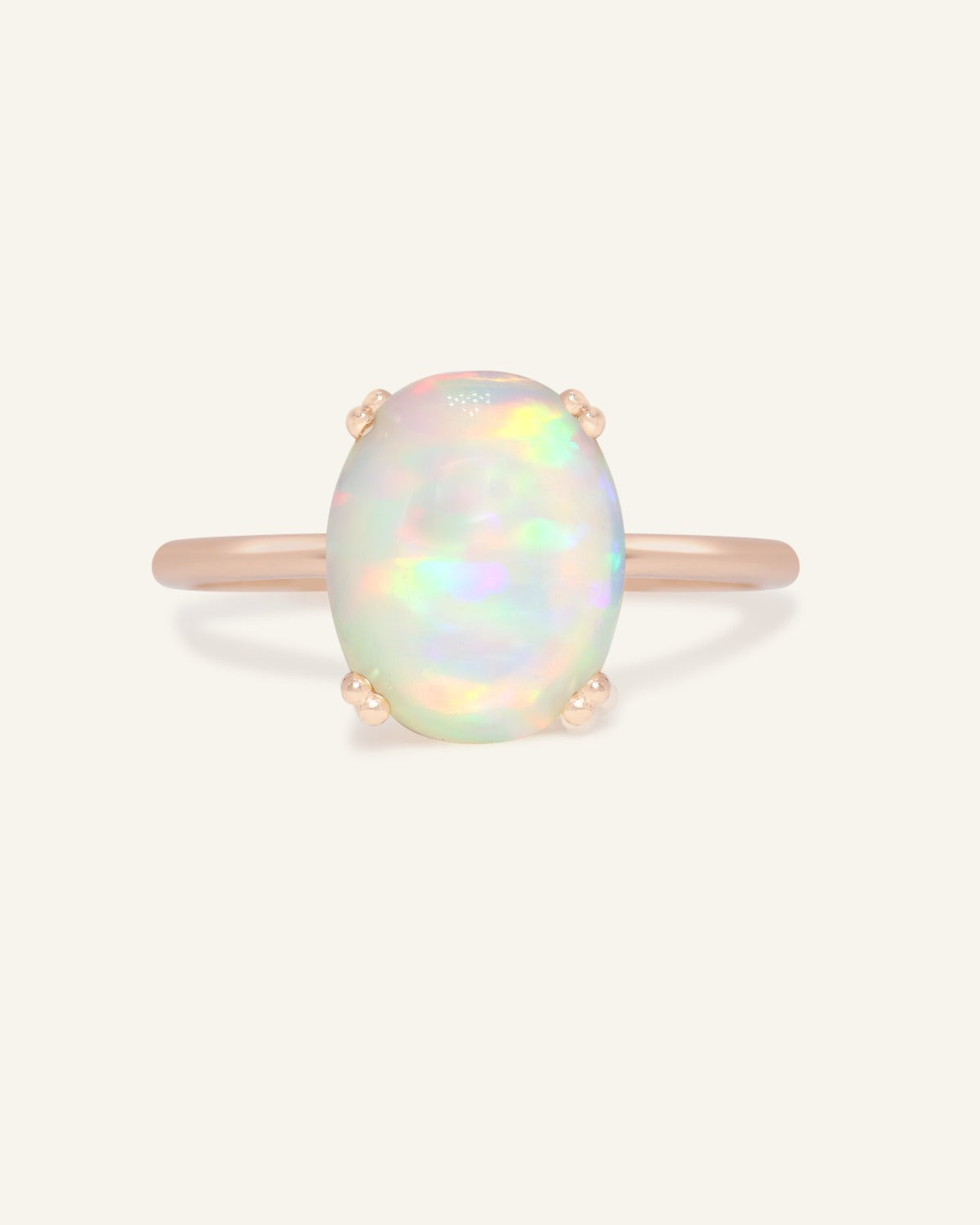 Luna Ethiopian Opal Ring in rose gold, front view of the oval opal ring on warm ivory