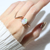 Luna Ethiopian Opal Ring in rose gold, worn on a hand beside an angular rose gold ring
