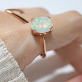 Luna Ethiopian Opal Ring in rose gold, side-angle close-up of the opal setting worn on a hand