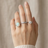 Luna Ethiopian Opal Ring in silver, worn on an open hand with two silver rings