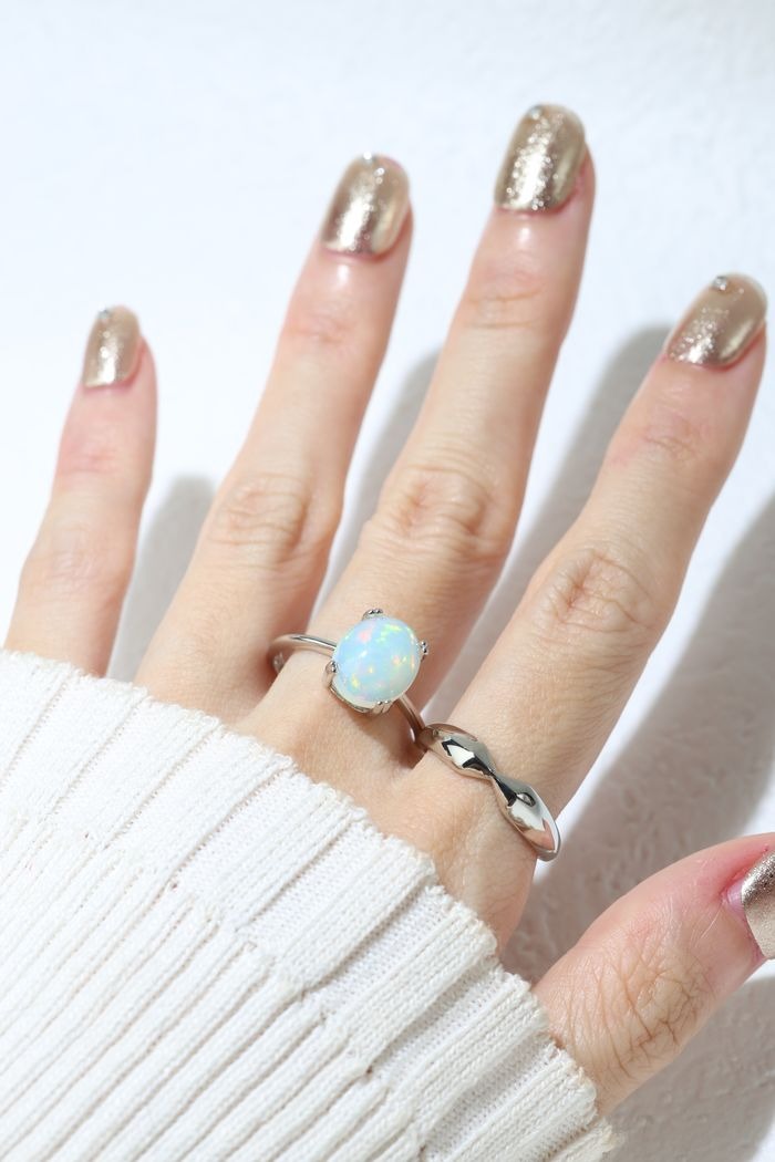 Luna Ethiopian Opal Ring in silver, worn on an open hand beside a silver leaf ring