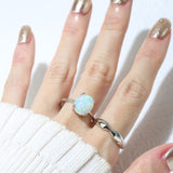 Luna Ethiopian Opal Ring in silver, worn on an open hand beside a silver leaf ring