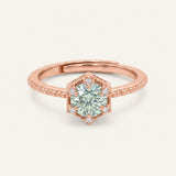 Rose gold mint green moissanite ring with a floral CZ halo on an ivory background