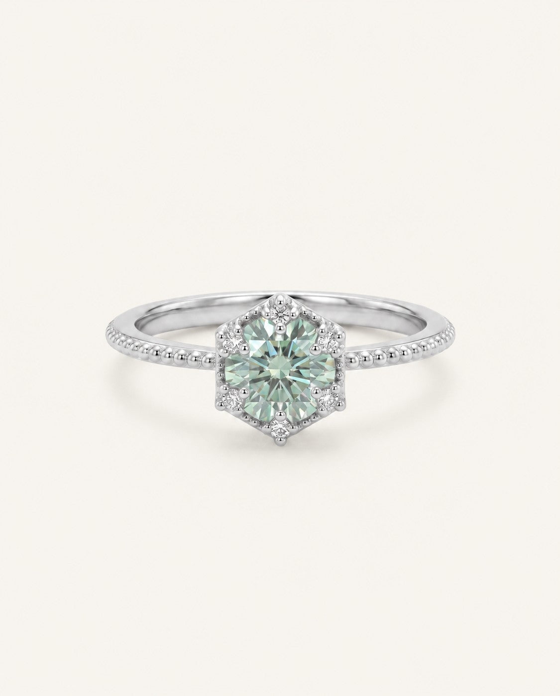 Silver mint green moissanite ring with a floral CZ halo on an ivory background