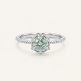 Silver mint green moissanite ring with a floral CZ halo on an ivory background