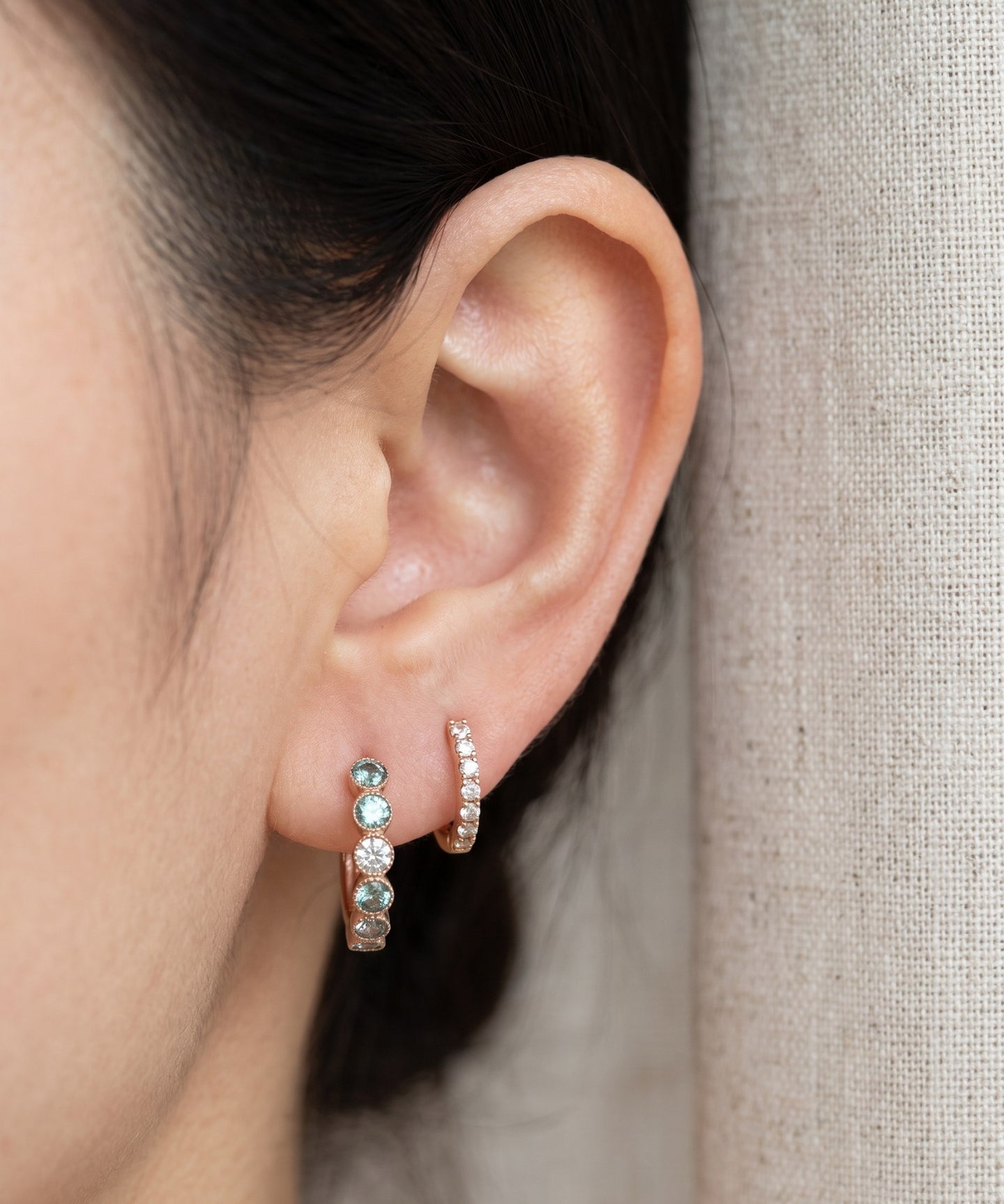 Mint ombré moissanite rose gold hoop earring worn beside a small hoop