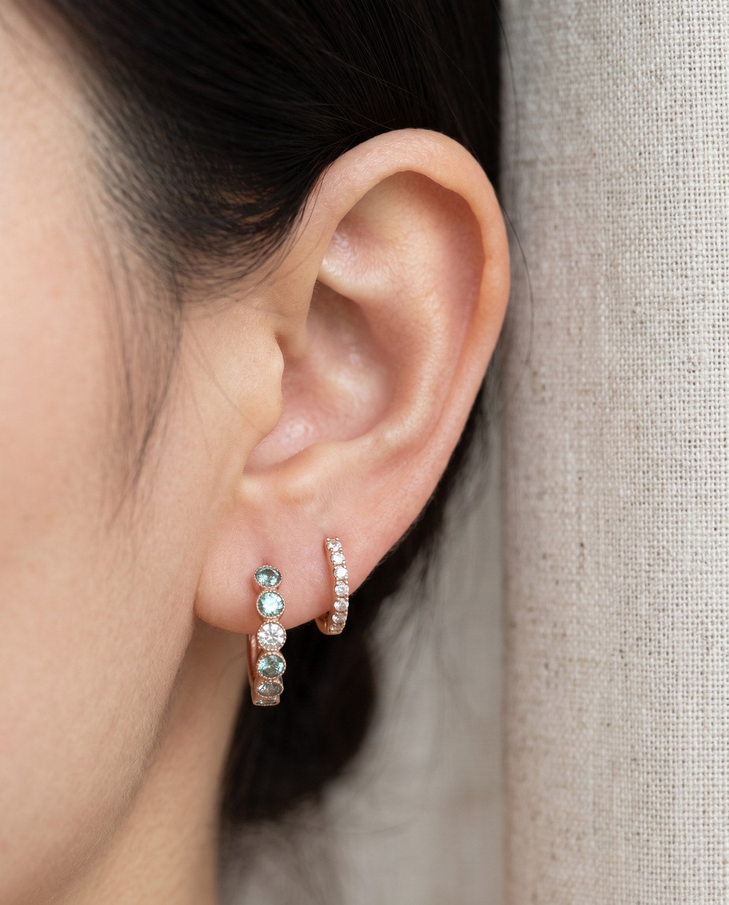 Mint ombré moissanite rose gold hoop earring worn beside a small hoop