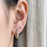 Close-up of mint ombré moissanite rose gold hoop earring styled with a stud