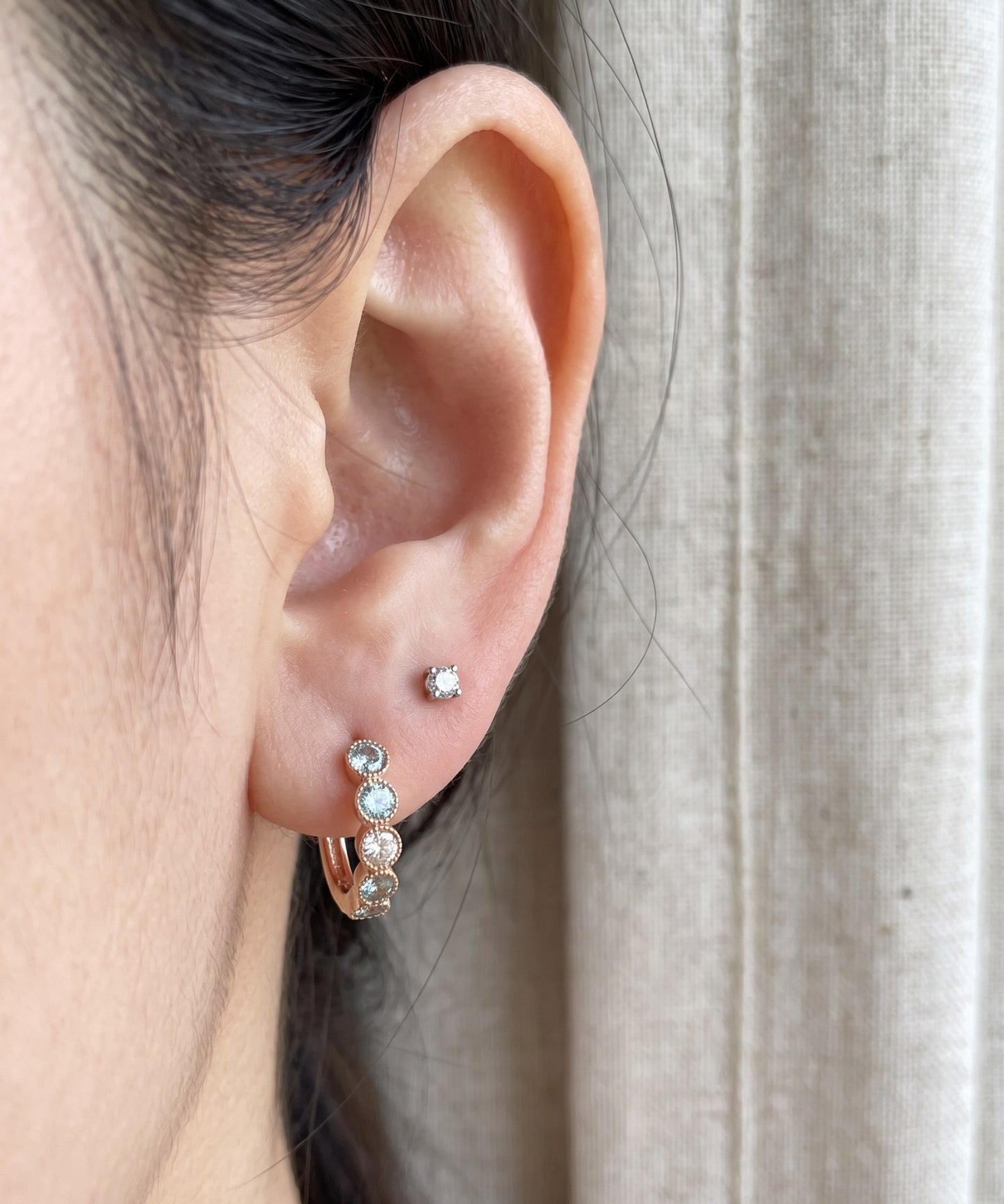 Close-up of mint ombré moissanite rose gold hoop earring styled with a stud