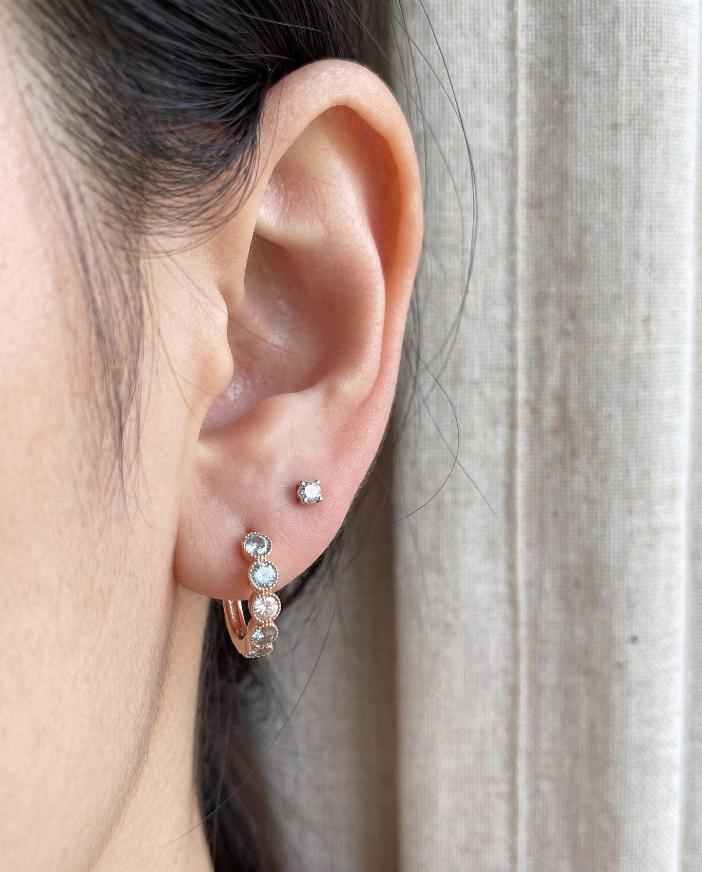 Close-up of mint ombré moissanite rose gold hoop earring styled with a stud