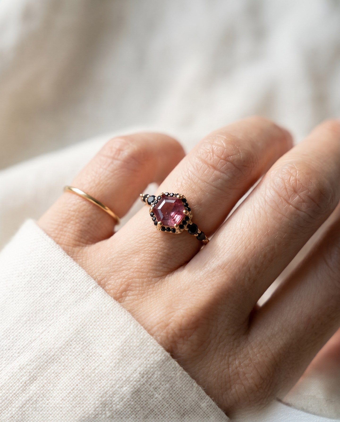 Nocturne Halo Hexagon Ring in rose gold worn on a hand, lab-grown alexandrite showing raspberry-pink tones with black CZ accents