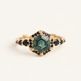 Nocturne Halo Hexagon Ring in yellow gold with green lab-grown alexandrite and black CZ halo on an ivory background