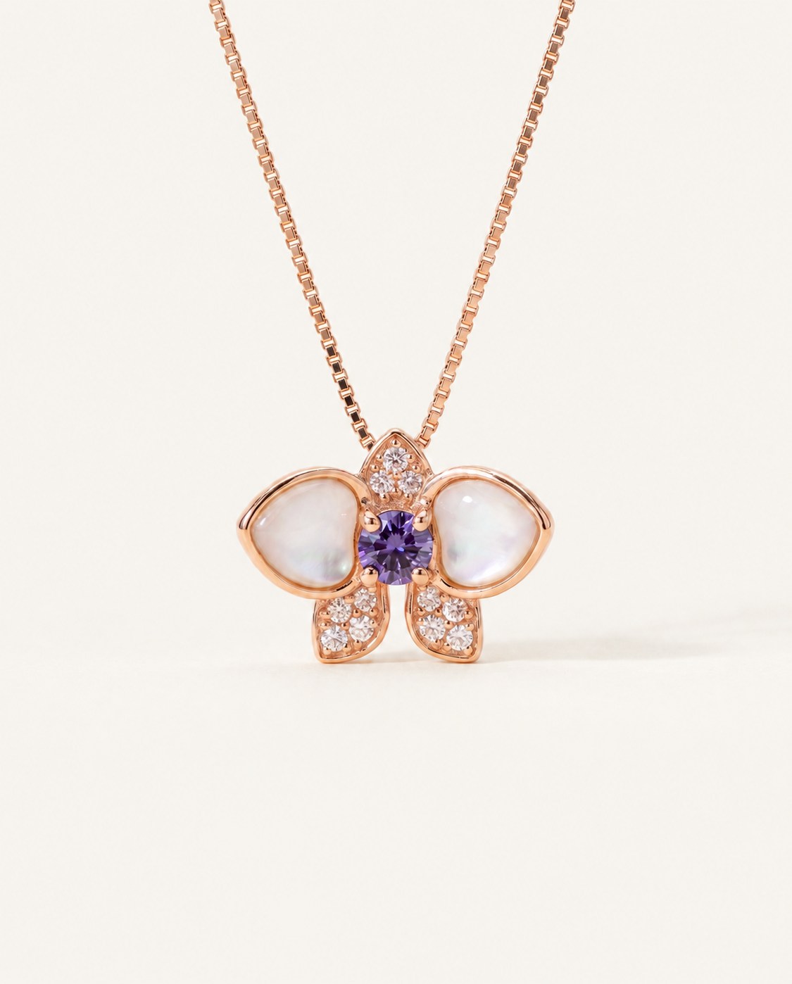 Orchid Bloom Mother of Pearl Necklace in rose gold with iridescent wings and purple spinel centre on a soft ivory background