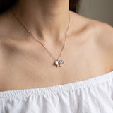 Orchid Bloom Mother of Pearl Necklace in rose gold with iridescent wings and purple spinel centre worn at the collarbone