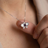 Orchid Bloom Mother of Pearl Necklace in silver with iridescent wings and purple spinel centre worn at the collarbone
