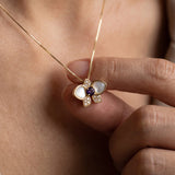 Orchid Bloom Mother of Pearl Necklace in yellow gold with iridescent wings and purple spinel centre worn at the collarbone