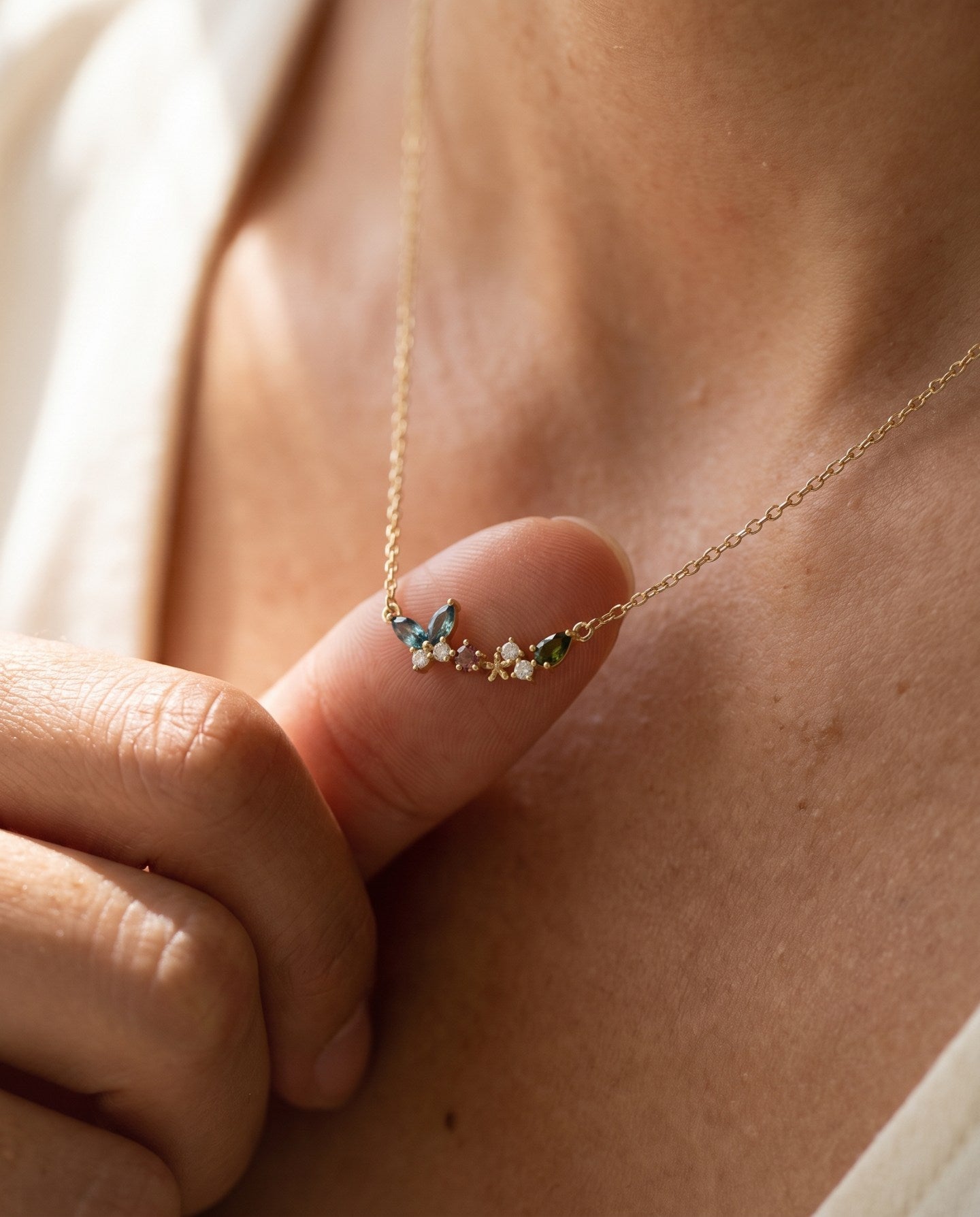 Papillon and Blossom butterfly necklace in rose gold with teal apatite, rhodolite garnet and chrome diopside worn at the collarbone
