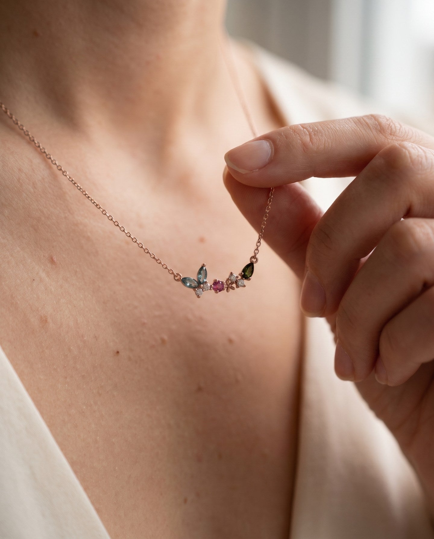 Papillon and Blossom butterfly necklace in rose gold with teal apatite, rhodolite garnet and chrome diopside worn at the collarbone