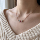 Papillon and Blossom butterfly necklace in rose gold with teal apatite, rhodolite garnet and chrome diopside worn at the collarbone