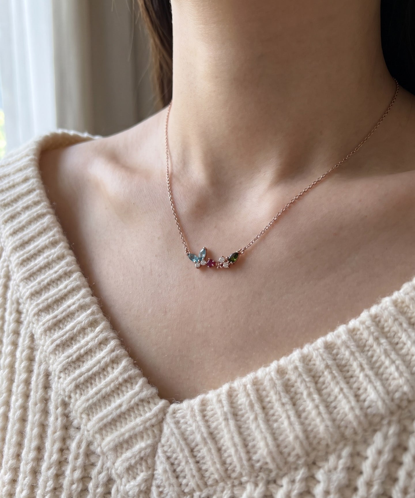 Papillon and Blossom butterfly necklace in rose gold with teal apatite, rhodolite garnet and chrome diopside worn at the collarbone