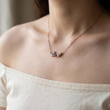 Papillon and Blossom butterfly necklace in rose gold with teal apatite, rhodolite garnet and chrome diopside worn at the collarbone